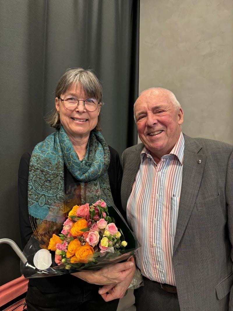 Foredragsholder Anne Spurkland st&#229;r smilende ved siden av styremedlem Jan Anker-Nilssen med blomsterbukett i armene. Foto: