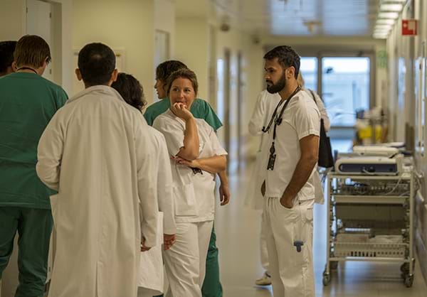 Leger som st&#229;r og snakker i en sykehuskorridor. Foto: Ahus